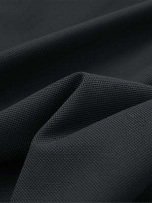 Close-up texture of black waffle texture 1/4 zip pullover fabric showing detailed waffle knit material and weave.