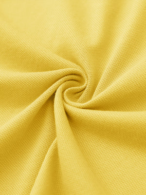 Fabric close-up of yellow cotton blend pique plain shirt, breathable pique fabric texture.