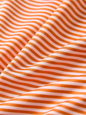 Texture close-up of Kids stripe golf polos with soft fabric and bright orange stripe stripes