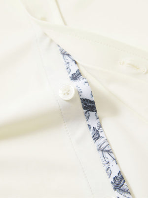 Detail view of buttons on cream cool print plain button up shirts