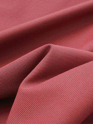 Close-up texture of brick red waffle texture 1/4 zip pullover fabric showing detailed waffle knit material and weave.