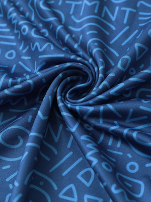Close-up of blue graffiti golf performance print boys golf polo fabric showing moisture-wicking texture and vibrant pattern.