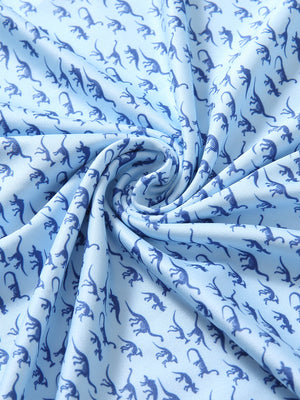 Close-up of blue dinosaur golf performance print boys golf polo fabric showing moisture-wicking texture and vibrant pattern.