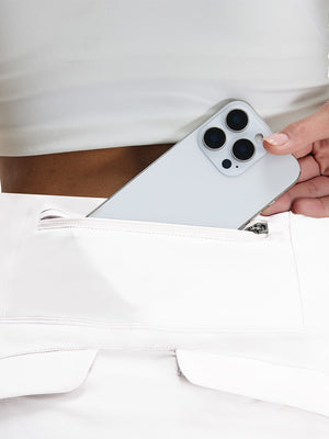 Detail view of pocket on white women's stretch a-line golf skort with 7 pockets