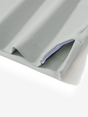 Detail view of hem on silver grey dry fit waffle textured collared golf shirts