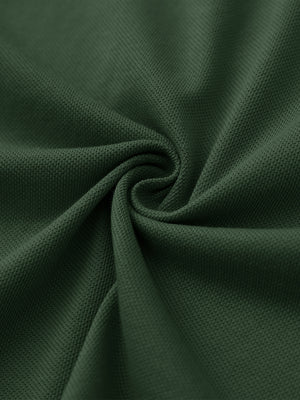 Fabric close-up of dark green cotton blend pique plain shirt, breathable pique fabric texture.