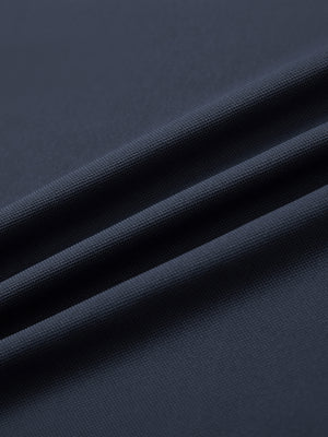 Close-up of dark grey ventilated pique performance polo fabric texture.