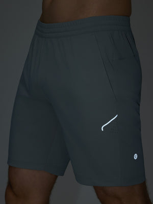 Detail of glow in the dark feature on grey blue 4 way stretch breathable workout athletic shorts