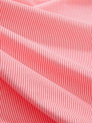 Close-up texture of pink coral white comfy breathable pin-stripe texture golf polos fabric showing weave detail.