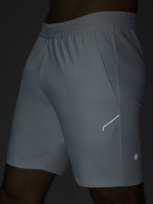 Detail of glow in the dark feature on white 4 way stretch breathable workout athletic shorts