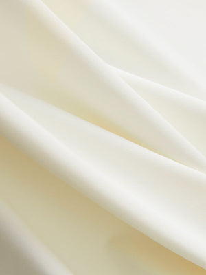 Close-up texture of cream cool print plain button up shirts fabric showing detailed print and weave.