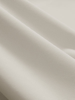 Close-up texture of oyster gray dry fit waffle textured collared golf shirts fabric showing weave detail.