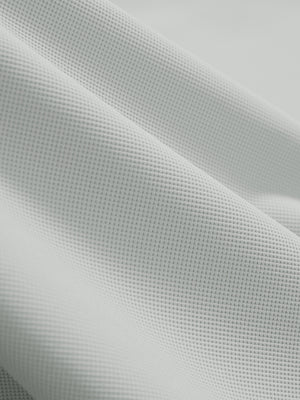 Close-up texture of silver grey dry fit waffle textured collared golf shirts fabric showing weave detail.