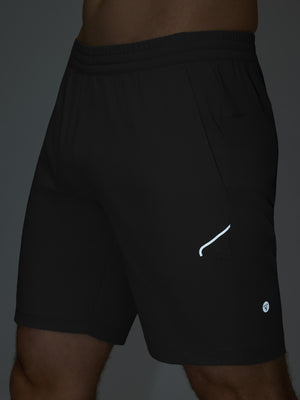Detail of glow in the dark feature on black 4 way stretch breathable workout athletic shorts