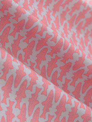 Close-up texture of pink small fish premium ribbed collar print polo shirts fabric showing detailed premium material and weave.