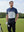 Model in navyglacier grey premium performance polo holding a golf club outdoors, half-body shot