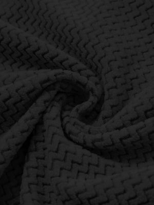 Fabric close-up of warm stretchy quarter zip with pocket, smooth knit texture and flexible feel in black