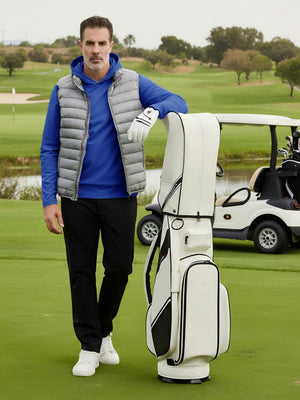 Model leaning on a golf bag on course, wearing dry fit stretchy sweatshirts hoodies in relaxed klein blue style