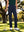 Outdoor front lower body shot of model holding golf club in navy women's lightweight high waisted golf pants